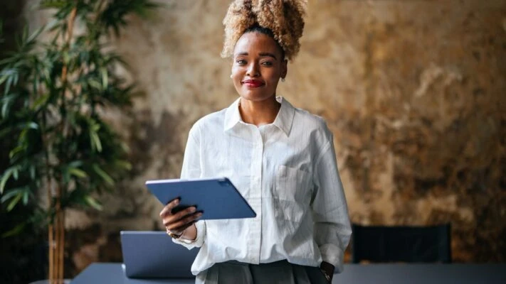 smiling lady completing cybersecurity training holding a tablet